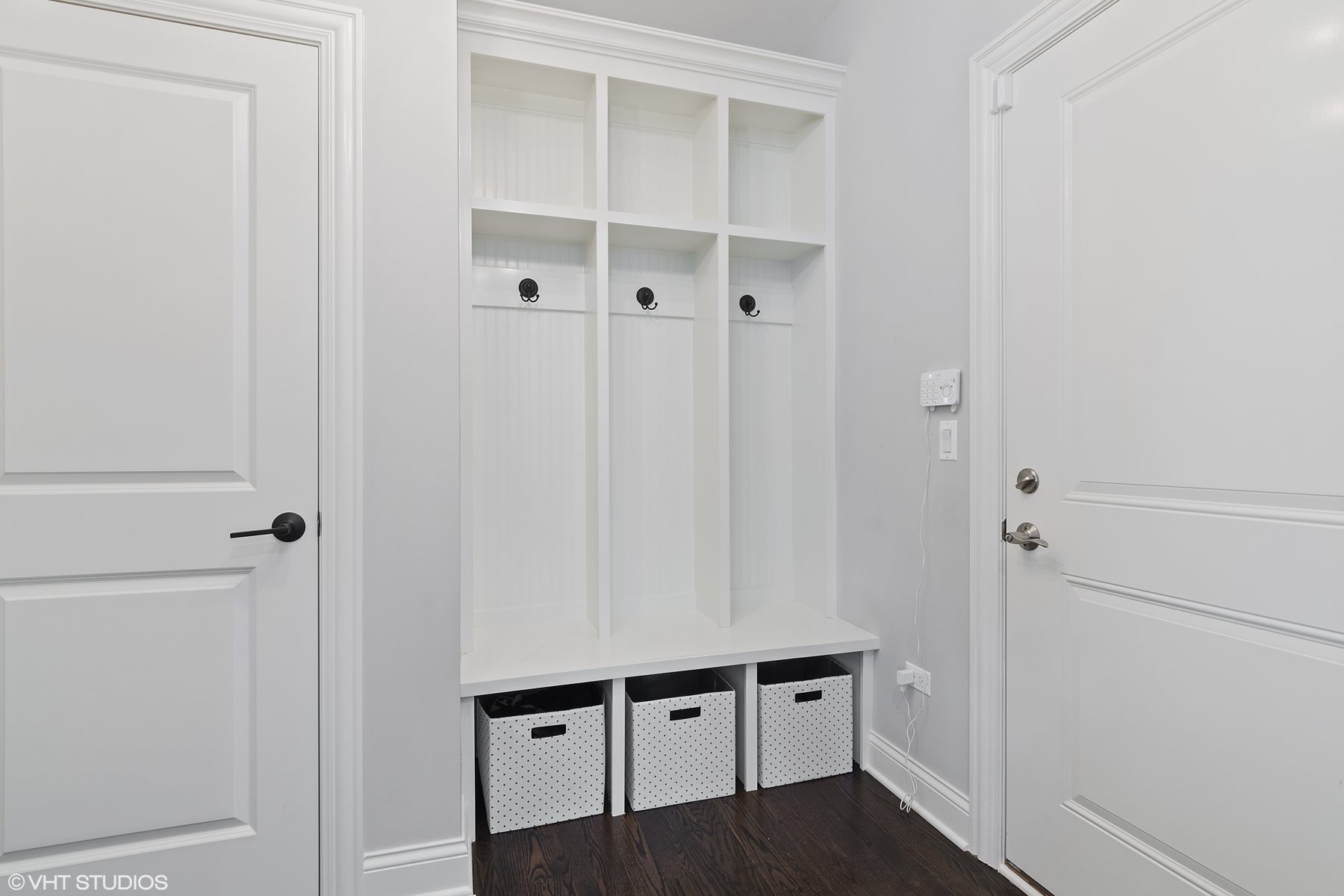Custom mudroom lockers with beadboard backs, iron hooks and a storage bench