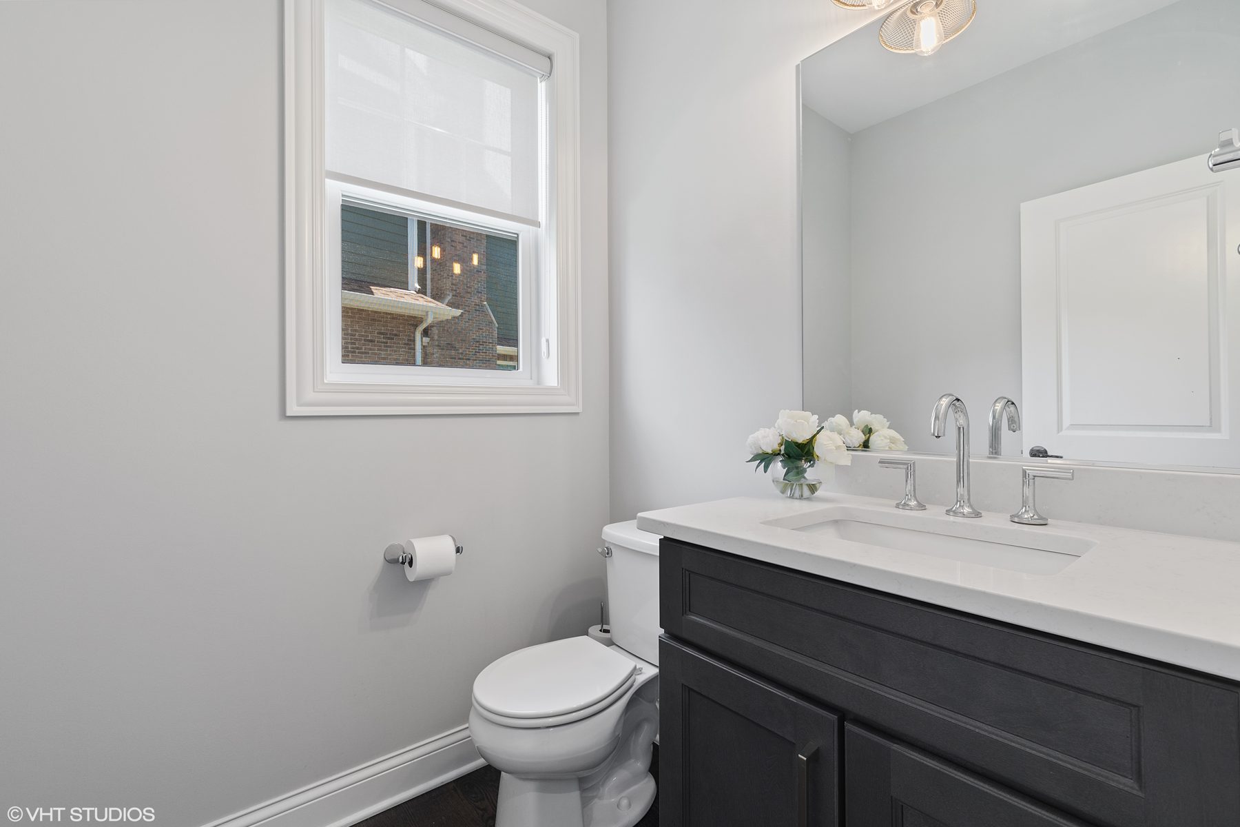 Powder room with a charcoal vanity, quartz top and polished chrome faucet